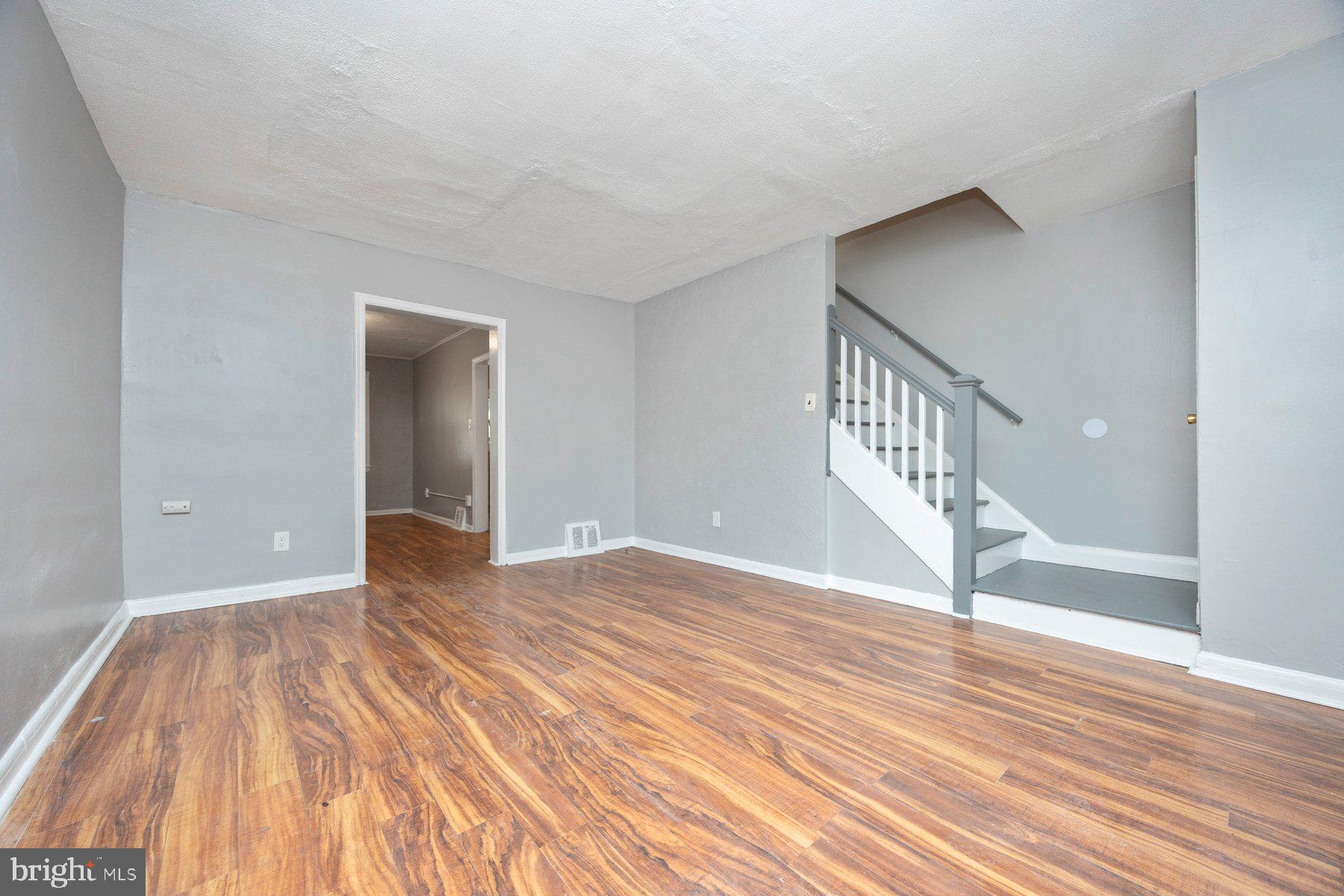 504 Roundview Road Baltimore, MD 21225 - Photo 9 of 26 a view of an empty room with wooden floor and entryway