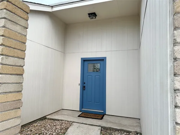 an empty room with wooden floor fireplace and windows