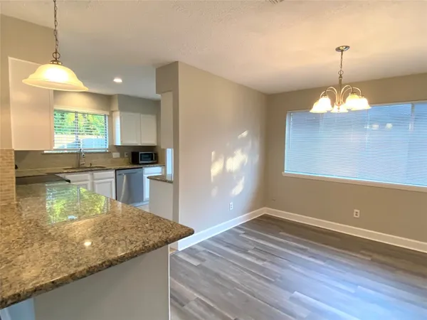 a kitchen with granite countertop a stove sink and cabinets