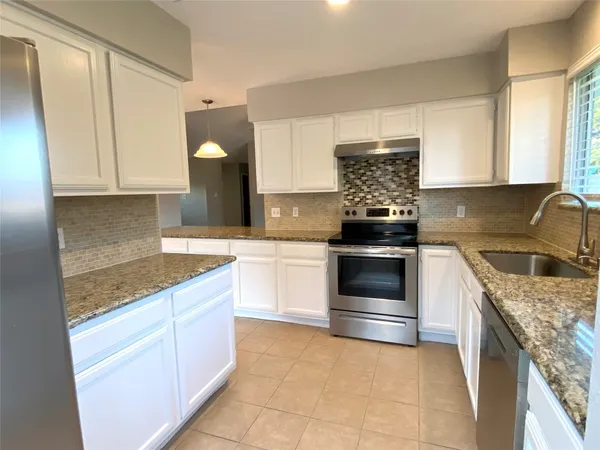 a kitchen with a sink a counter top space and cabinets