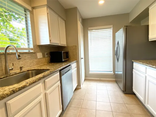 a view of a hallway with wooden floor and a chandelier