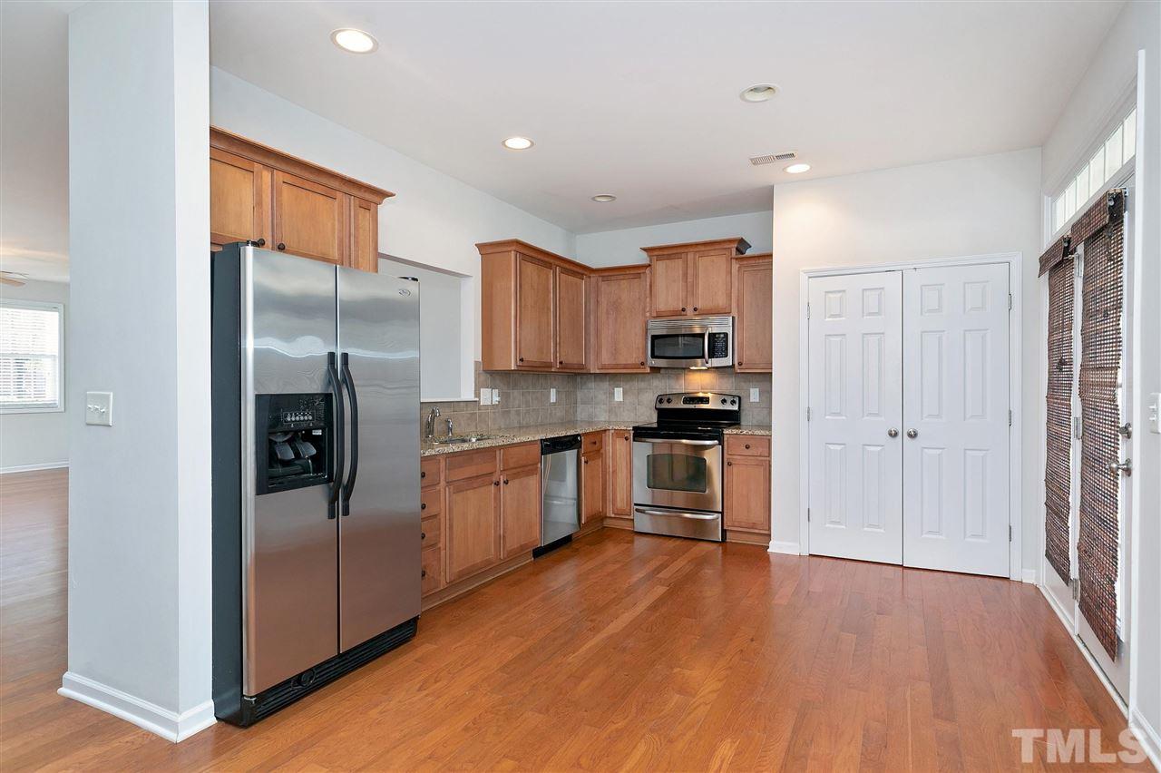 1340 Regulator Street Raleigh, NC 27603 - Photo 8 of 30 a kitchen with granite countertop stainless steel appliances a refrigerator cabinets and wooden floor