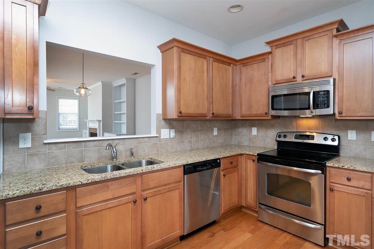 1340 Regulator Street Raleigh, NC 27603 - Photo 10 of 30 a kitchen with granite countertop a sink stove and microwave