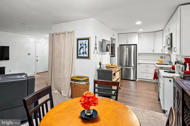 a kitchen with stainless steel appliances wooden floor and large windows