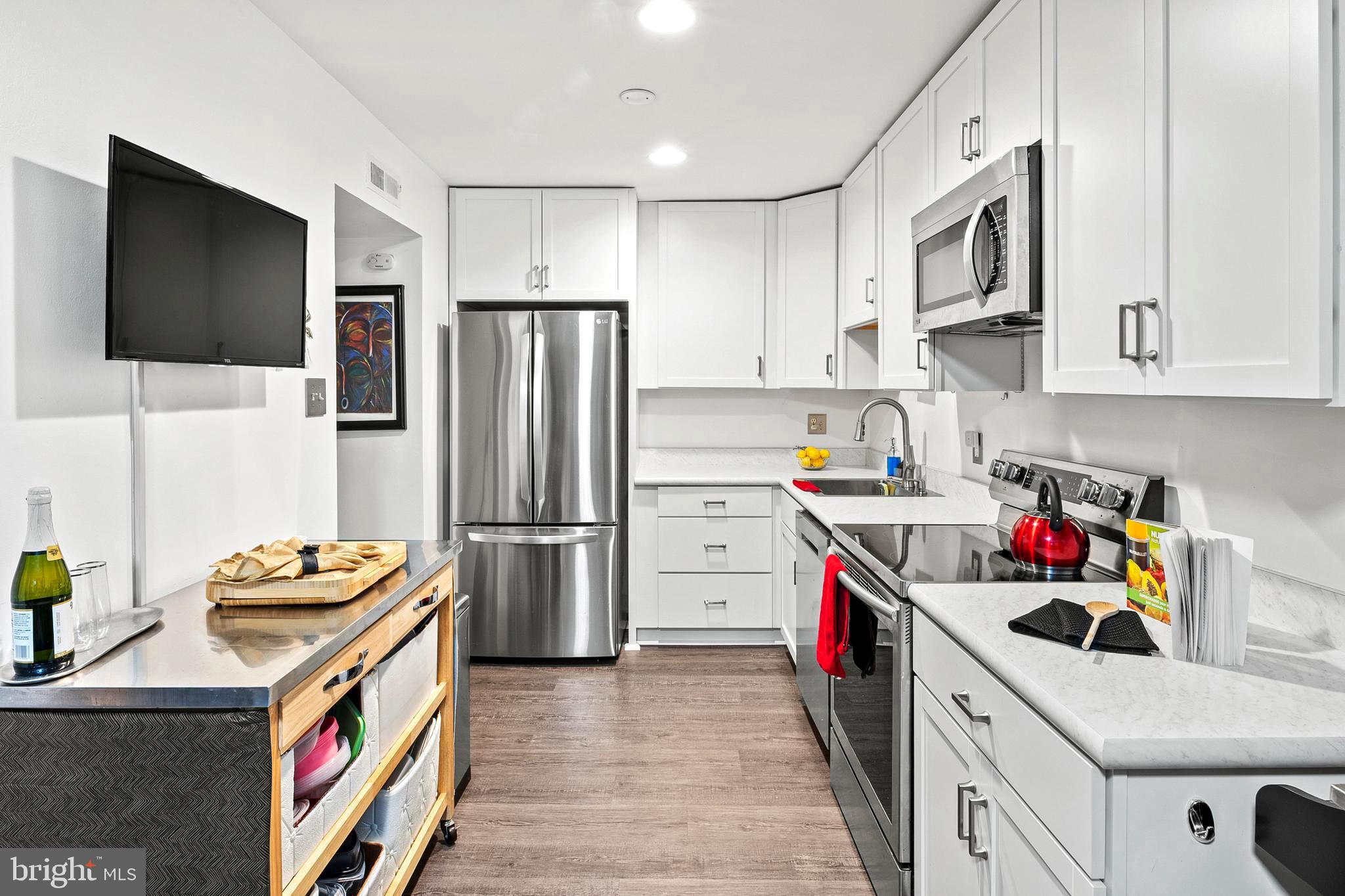 9550 Transfer Row Columbia, MD 21045 - Photo 9 of 27 a kitchen with stainless steel appliances a stove a refrigerator and a sink