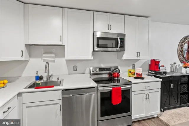 a kitchen with a sink a stove and cabinets