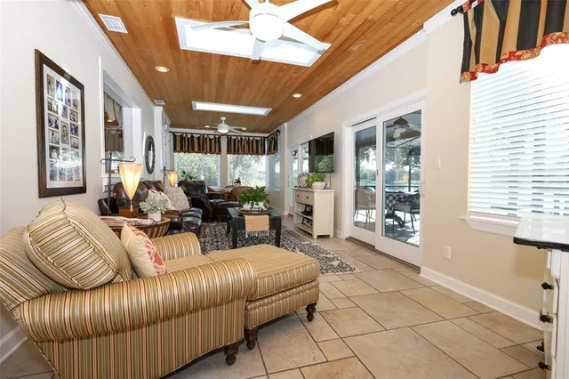 a living room with furniture a flat screen tv and a floor to ceiling window