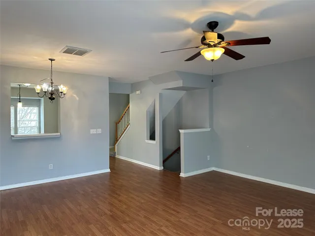 a view of a room with wooden floor and ceiling fan