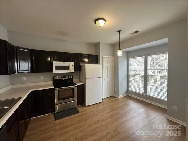 a kitchen with stainless steel appliances granite countertop a refrigerator and a stove top oven