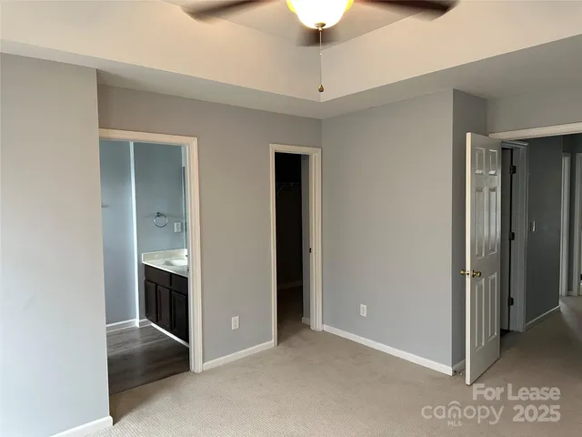 an empty room with closet and a ceiling fan