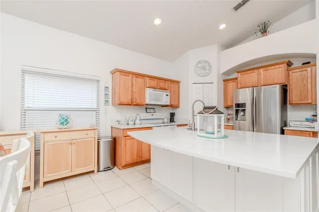 a kitchen with stainless steel appliances granite countertop a sink and a refrigerator