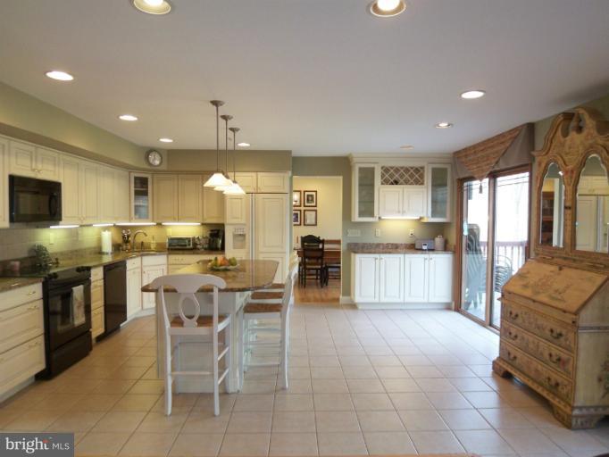 1226 Blue Mt Road Monkton, MD 21111 - Photo 21 of 30 a kitchen with stainless steel appliances granite countertop a stove top oven a sink a dining table and chairs