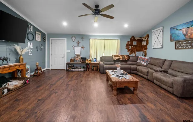 a living room with furniture and a wooden floor