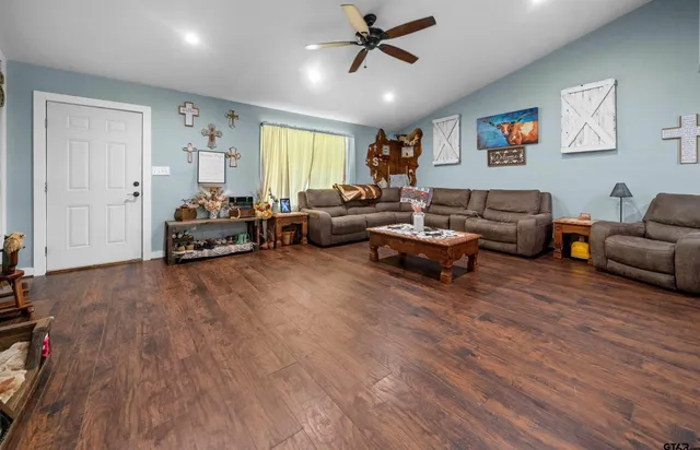 a living room with furniture and a wooden floor