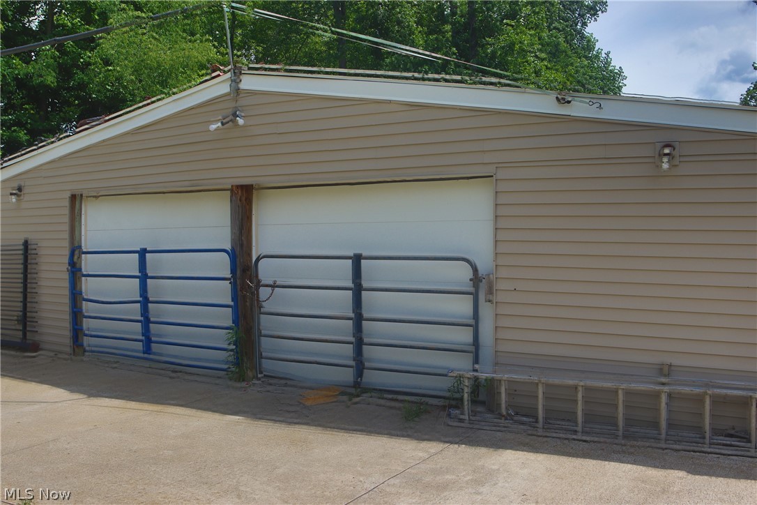 7250 Brakeman Road Painesville, OH 44077 - Photo 14 of 17 Attached two-car garage featuring horizontal siding and white garage doors