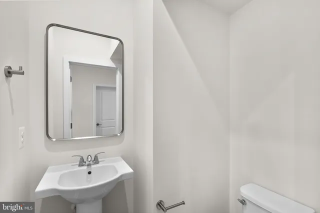 a bathroom with a sink a toilet and mirror