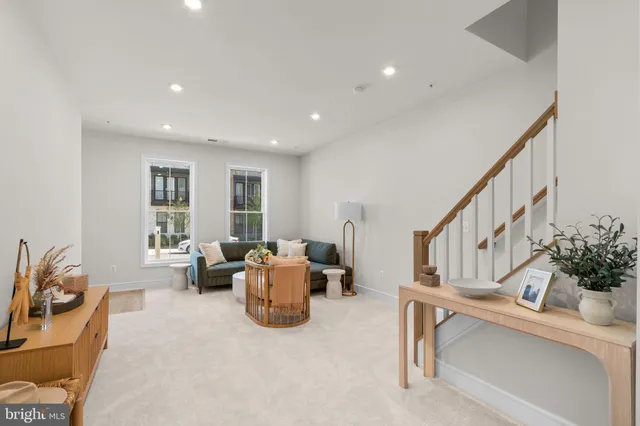 a living room with furniture stairs and a window