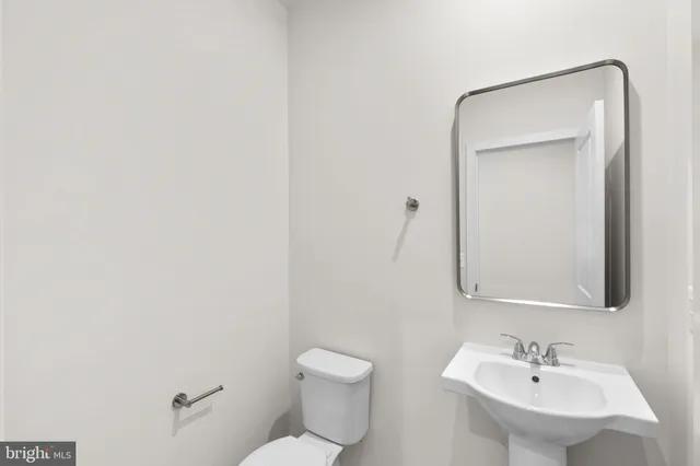 a bathroom with a toilet a sink and mirror