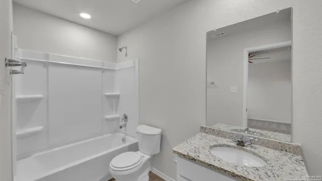 a view of an empty room and chandelier fan