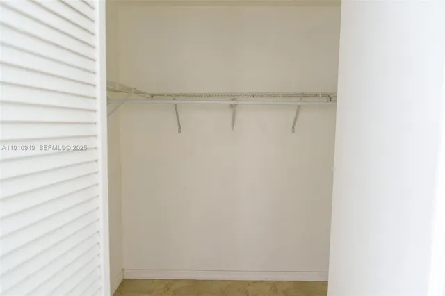 a view of walk in closet with empty racks