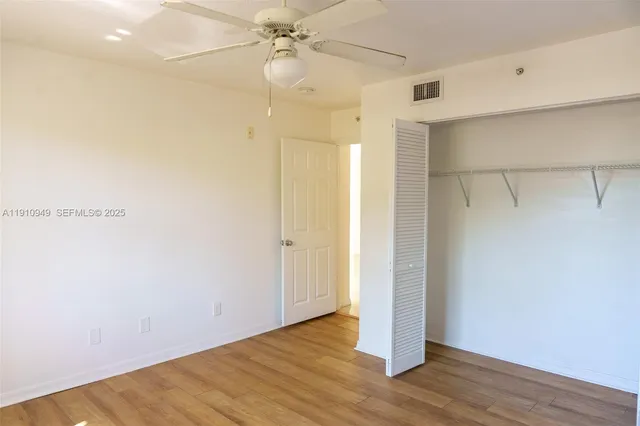 an empty room with a window and a fan