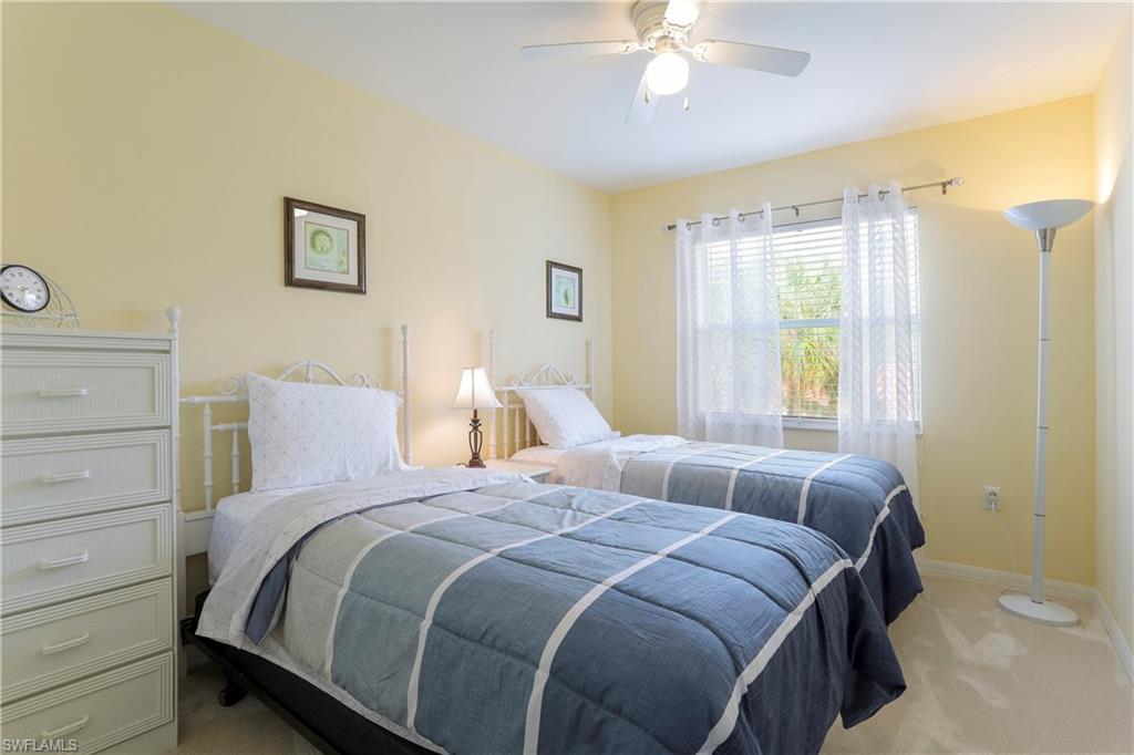337 Robin Hood Circle, Unit 204 Naples, FL 34104 - Photo 15 of 23 a bedroom with a bed and a chandelier