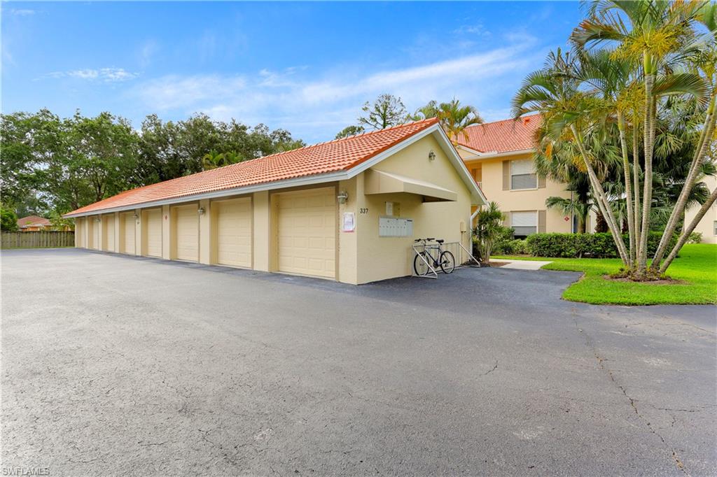 337 Robin Hood Circle, Unit 204 Naples, FL 34104 - Photo 18 of 23 a view of a house with a yard and garage