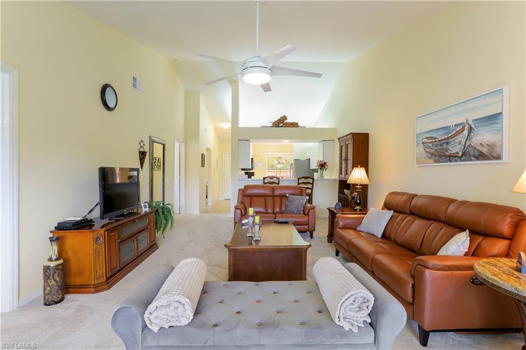 337 Robin Hood Circle, Unit 204 Naples, FL 34104 - Photo 4 of 23 a living room with furniture a flat screen tv and a fireplace