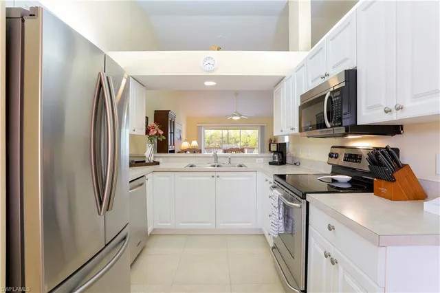 a kitchen with stainless steel appliances granite countertop a refrigerator a stove a sink and a microwave