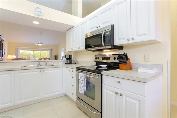 a kitchen with white cabinets and appliances