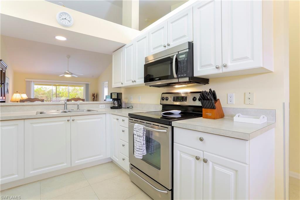 337 Robin Hood Circle, Unit 204 Naples, FL 34104 - Photo 10 of 23 a kitchen with white cabinets and appliances