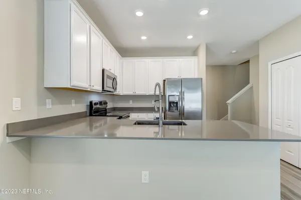 a kitchen with stainless steel appliances granite countertop a sink a stove and a refrigerator
