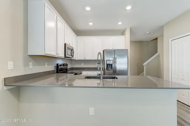 a kitchen with stainless steel appliances granite countertop a sink a stove and a refrigerator