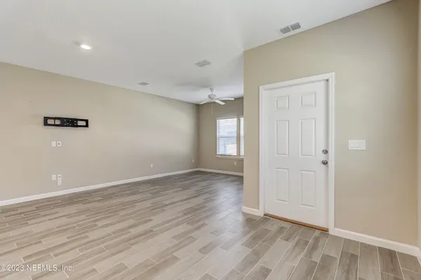 a view of an empty room with wooden floor