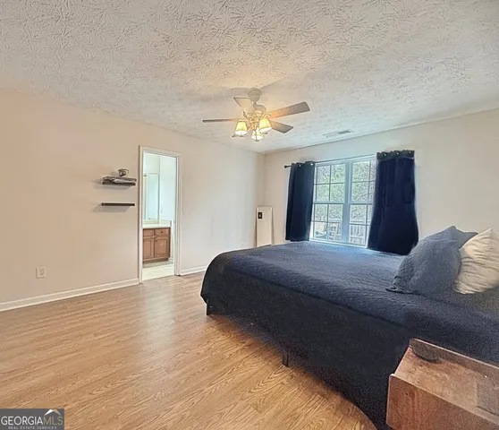a bedroom with a large bed and a chandelier