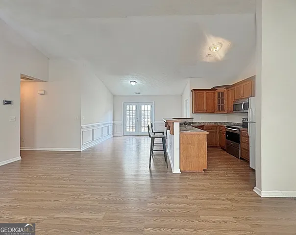 a view of kitchen with granite countertop stove top oven and cabinets