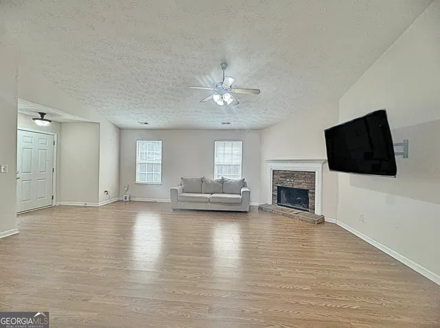 a view of empty room with fireplace and wooden floor