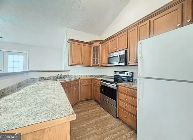 a kitchen with granite countertop a stove top oven and sink