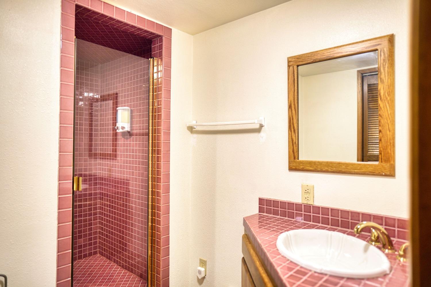 42917 Scenic Drive Oakhurst, CA 93644 - Photo 39 of 50 a bathroom with a sink a mirror and a shower