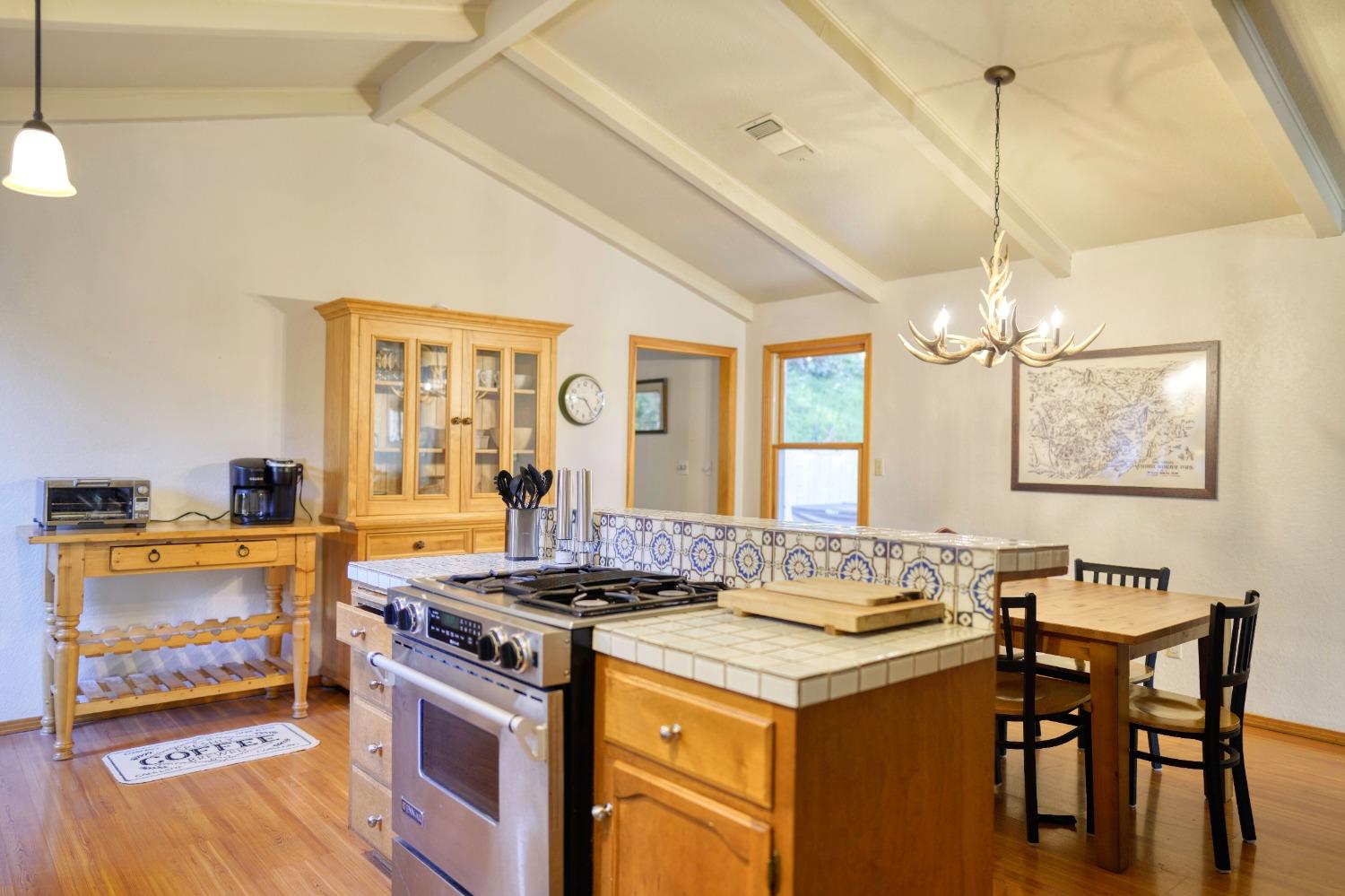 42917 Scenic Drive Oakhurst, CA 93644 - Photo 42 of 50 a kitchen with a stove a sink a dining table and chairs
