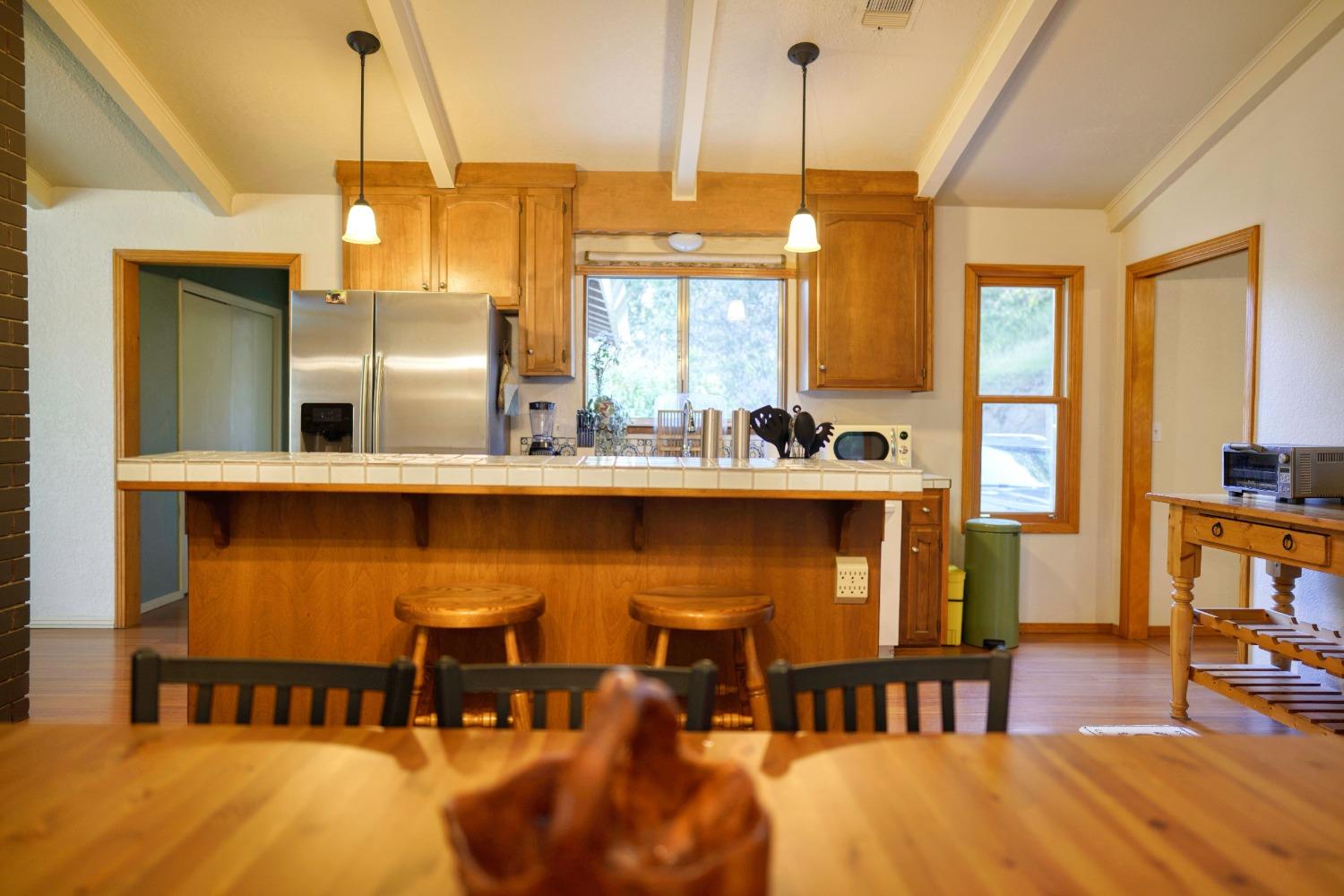 42917 Scenic Drive Oakhurst, CA 93644 - Photo 47 of 50 a kitchen with stainless steel appliances granite countertop a dining table chairs and chandelier