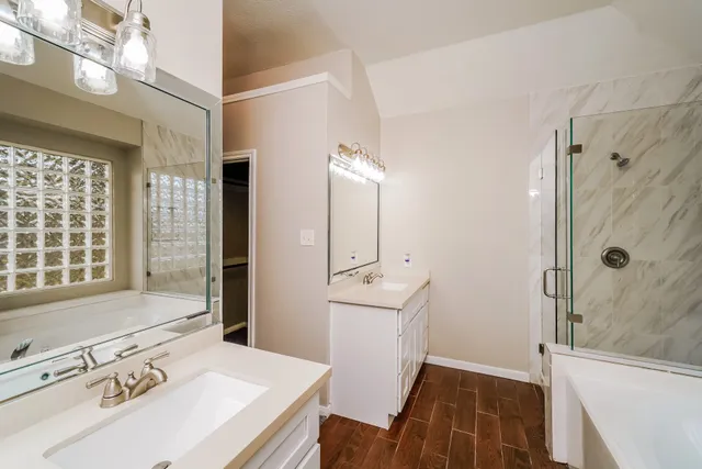 a bathroom with a tub sink and mirror