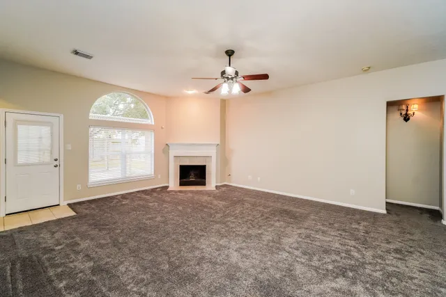 an empty room with fan and windows