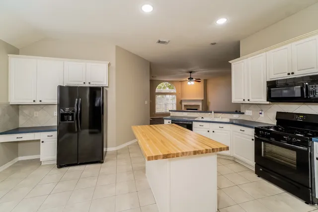 a kitchen with stainless steel appliances granite countertop a refrigerator stove top oven and sink