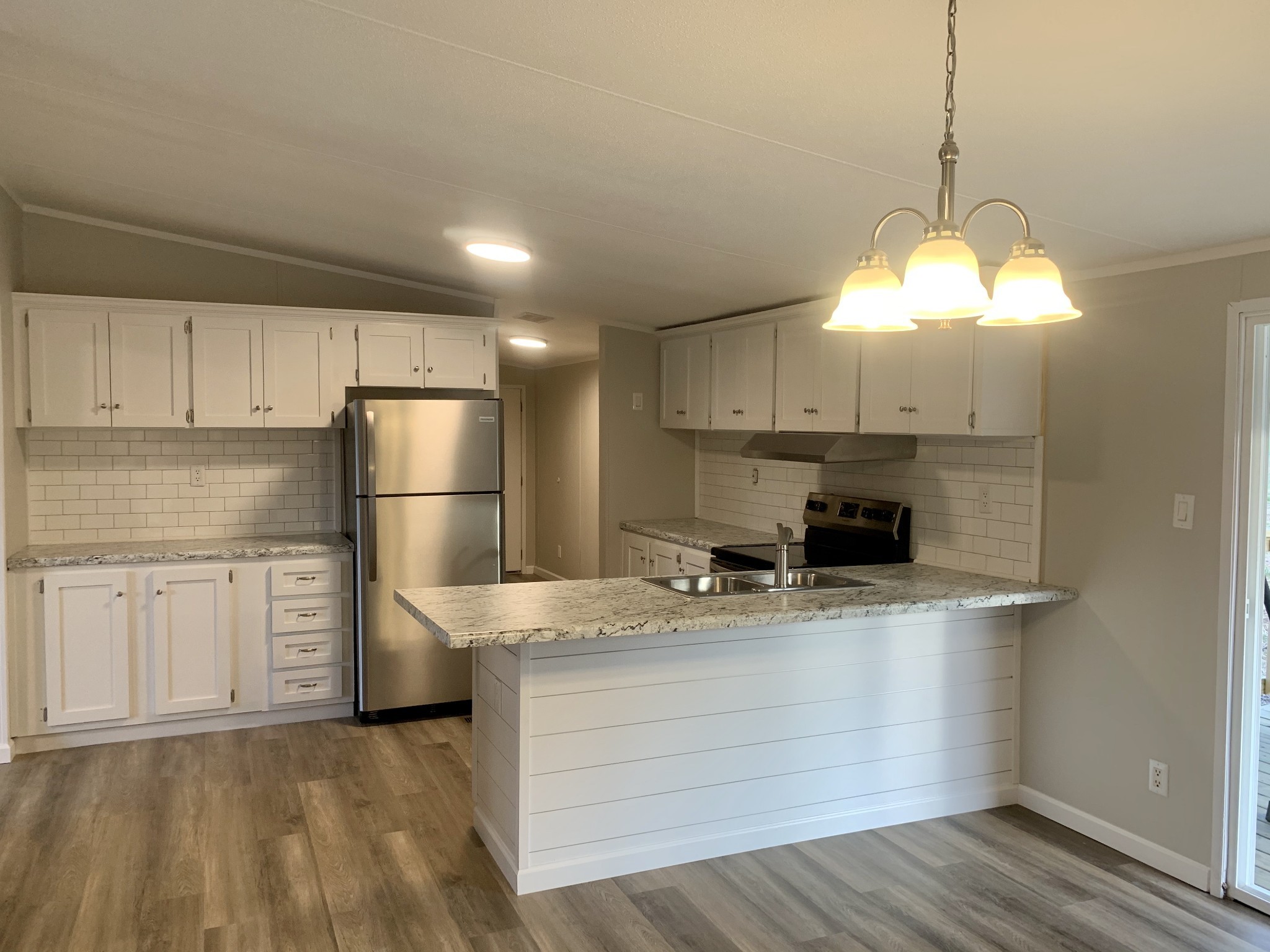784 Speck Road Lebanon, TN 37087 - Photo 7 of 35 a kitchen with a refrigerator a stove and a wooden floor