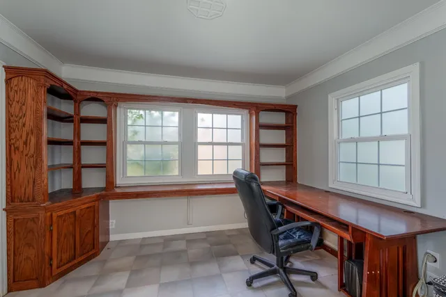 a view of a workspace with furniture and a window