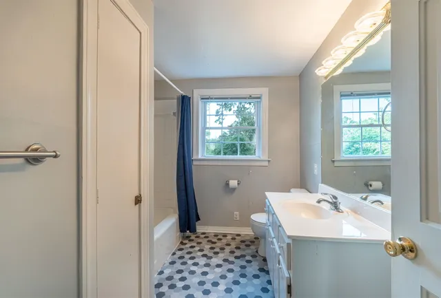 a bathroom with a sink a toilet and window