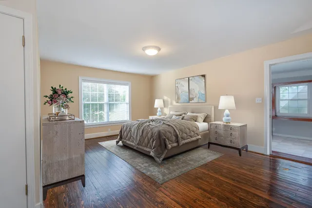 a spacious bedroom with a bed and wooden floor