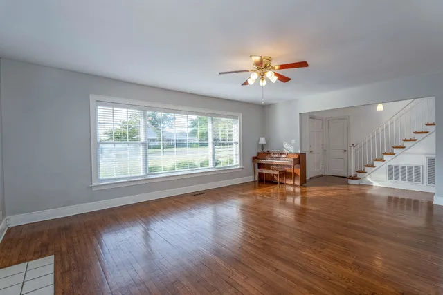 a view of a livingroom with wooden floor and a ceiling fan