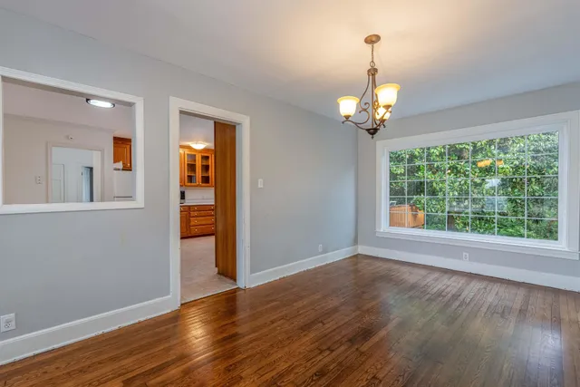 a view of a chandelier in big room and wooden floor